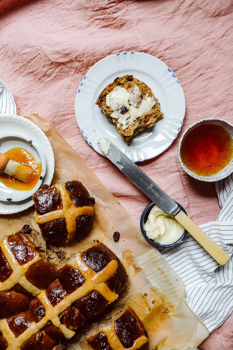 Hot cross bun fresh spread with butter, apricot glaze and a cup of tea